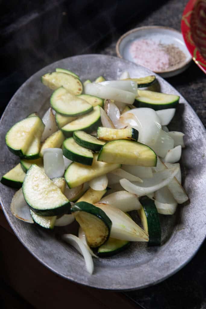 Sautéed sliced onion and zucchini in a plate. 
