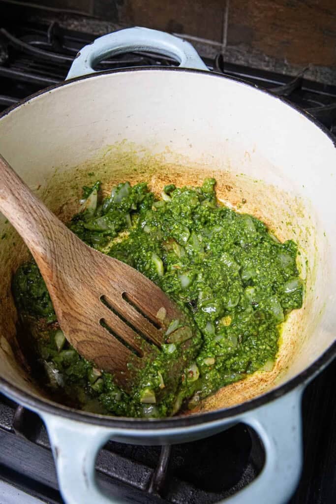 Sautéed thai  pesto sauce with a spatula in a pot over the stovetop. 