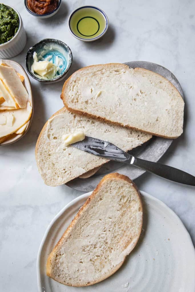 Sliced sourdough bread with butter spread on top.