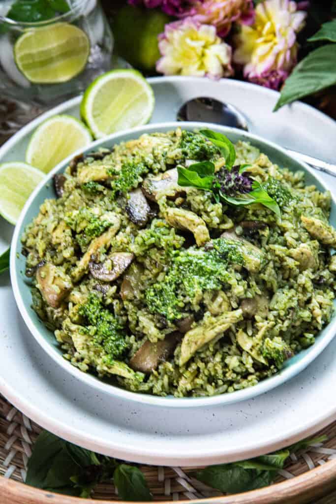 A plate of Thai basil pesto fried rice with lime wedges garnish sitting on top of a table.