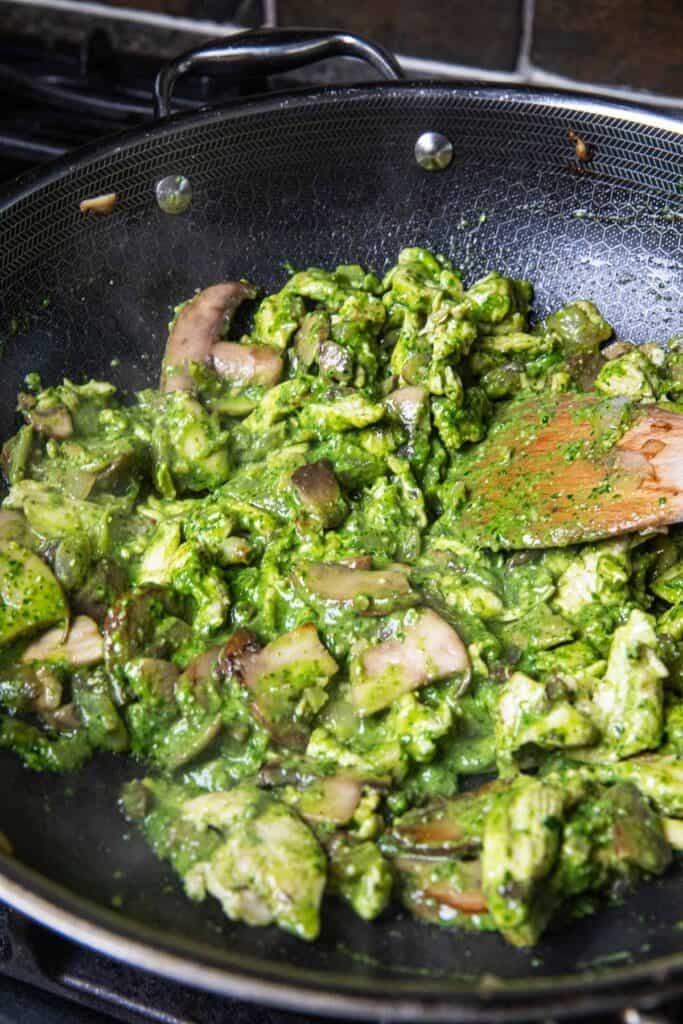 Thai basil pesto sauce stir-fried with chicken in a wok.