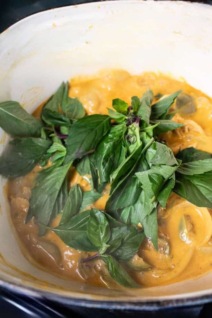 thai curry in a pot with thai basil.