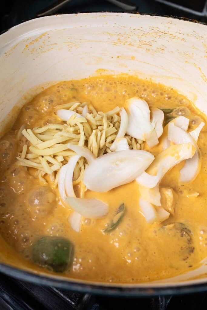 Thai eggplants in a pot of red curry sauce.