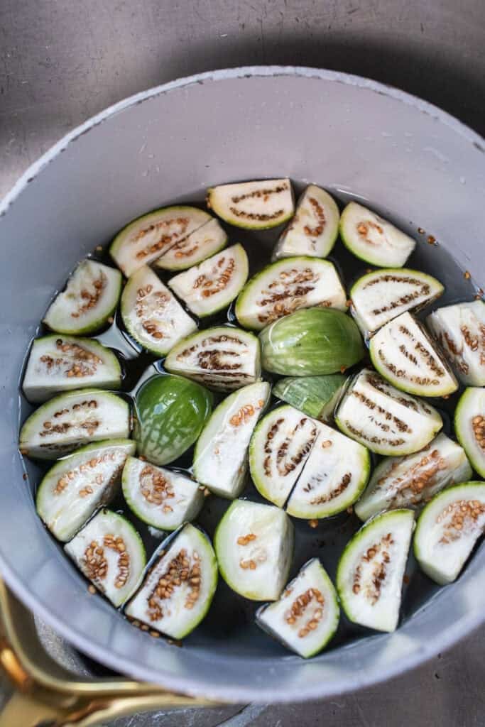 Sliced Thai eggplants in a pot of water.