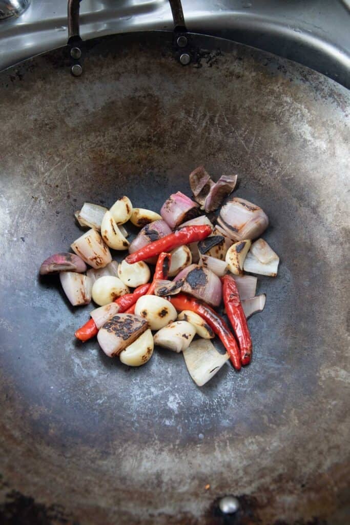 Dry roasted of Shallot, garlic, and chillies in a wok. 