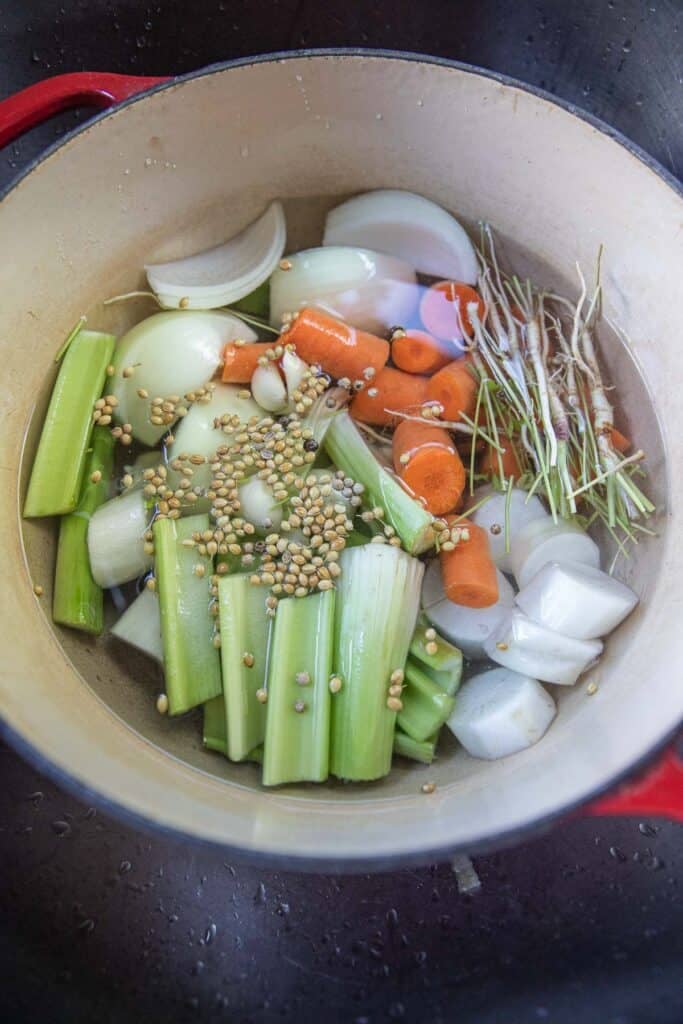 Fresh vegetables and herbs in a pot of water for vegetable stock.