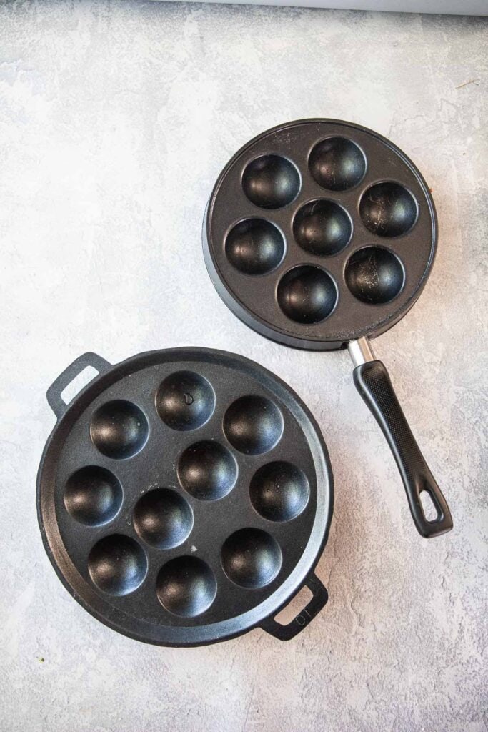 2 Kanom krok pans on a table.