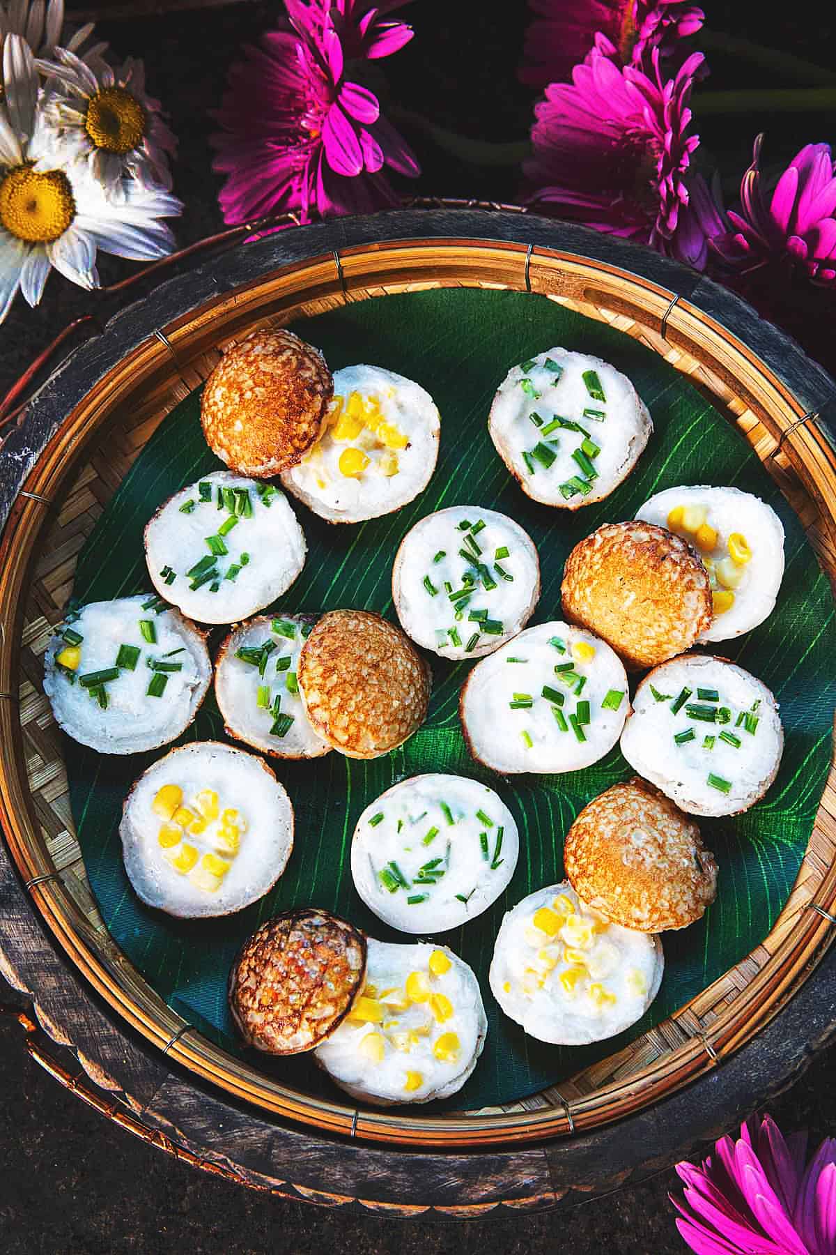 Kanom Krok or thai coconut pancake round pieces on a basket.