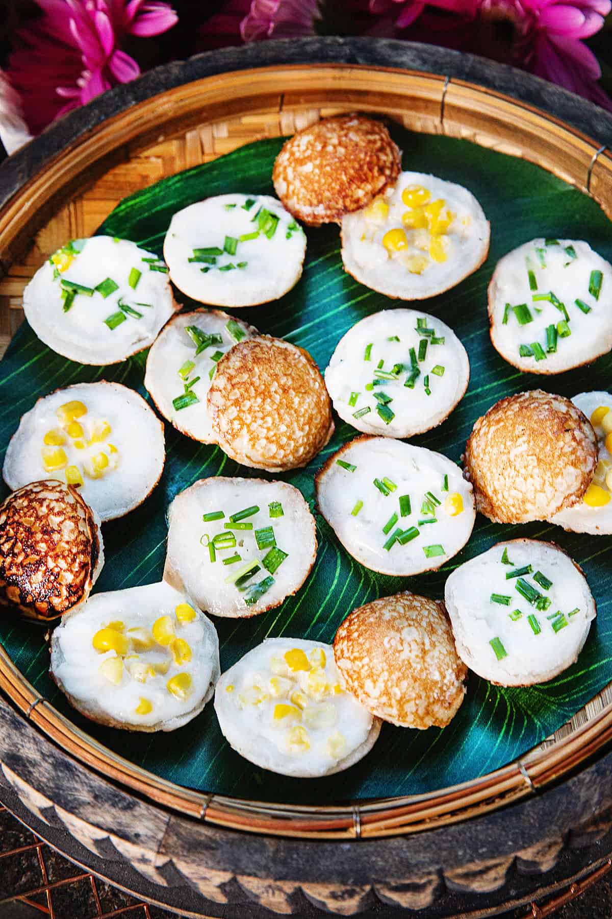 Kanom Krok or thai coconut pancake round pieces on a basket.
