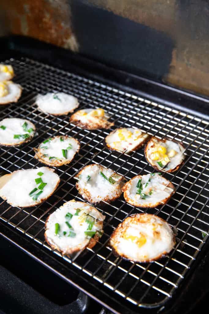 Cooked Thai kanom krok round pieces on a rack.