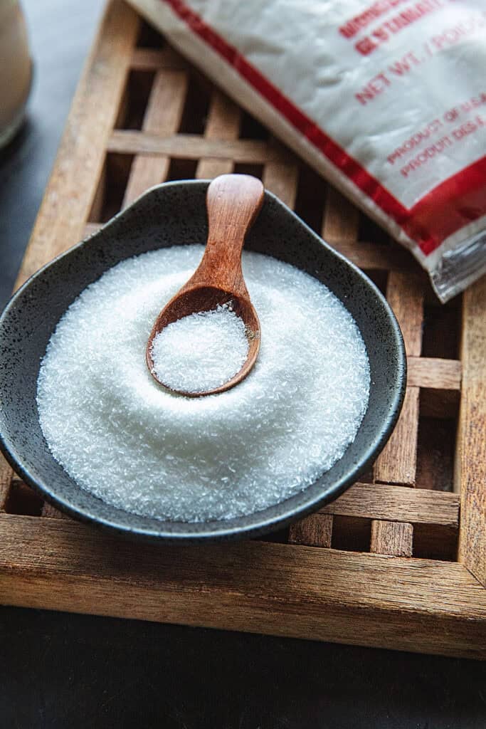 Msg powder in a small bowl with a wooden spoon inside.
