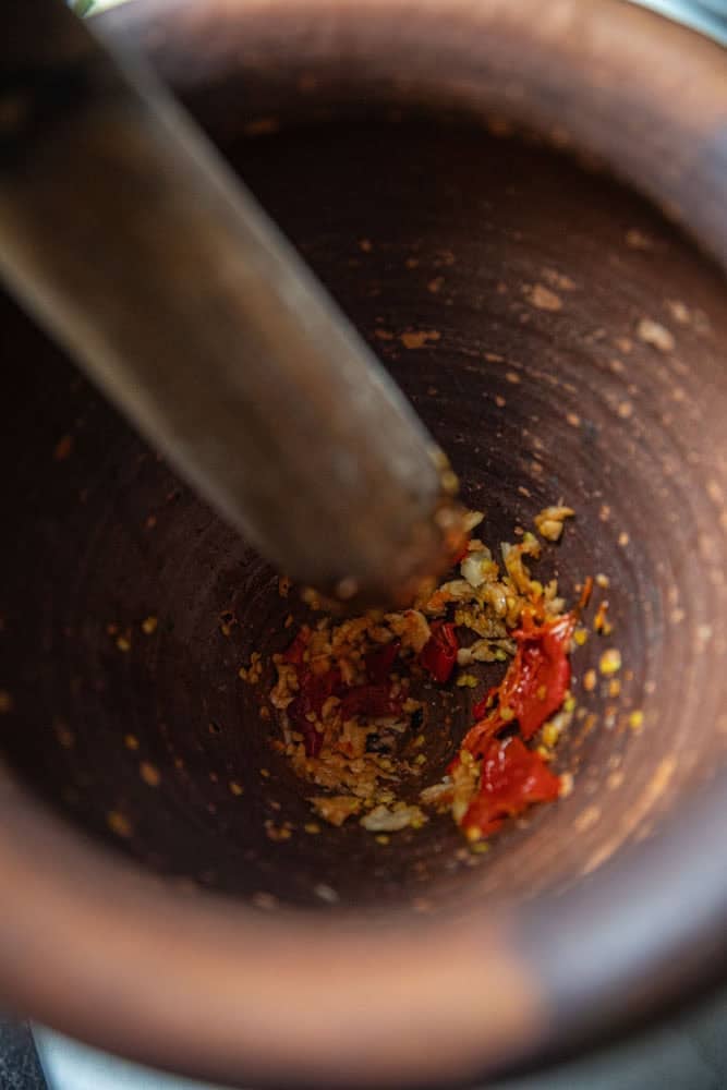 lightly crushed garlic and chilis in a mortar.