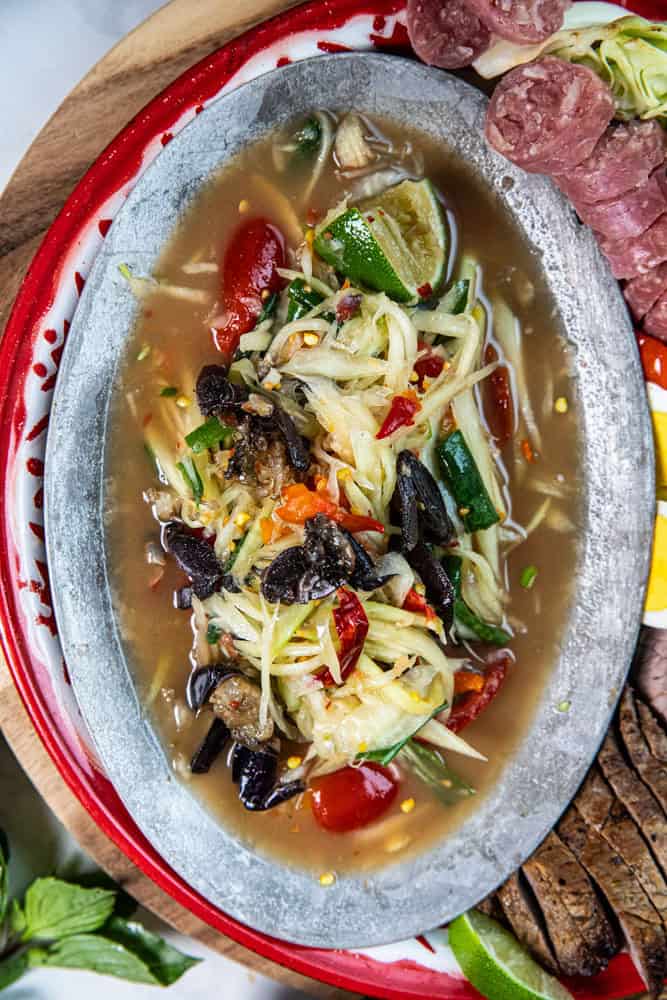 Som Tum pu Pla Ra in a plate over a table.