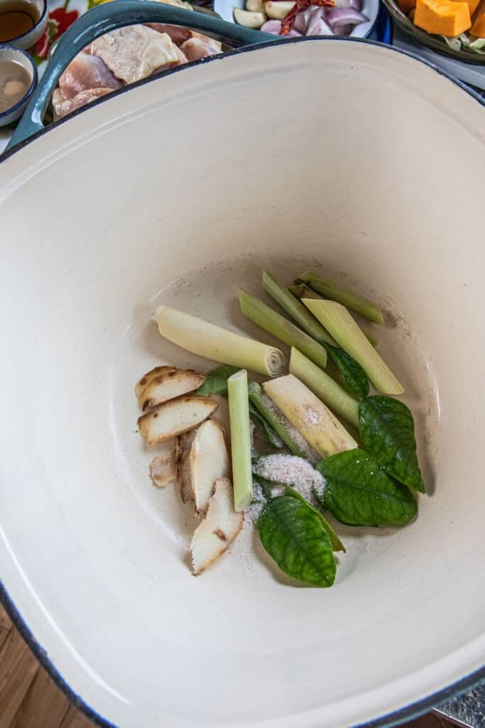 Lemongrass, galangal, and makrut lime leaves simmering in water for Gaeng Om Gai broth