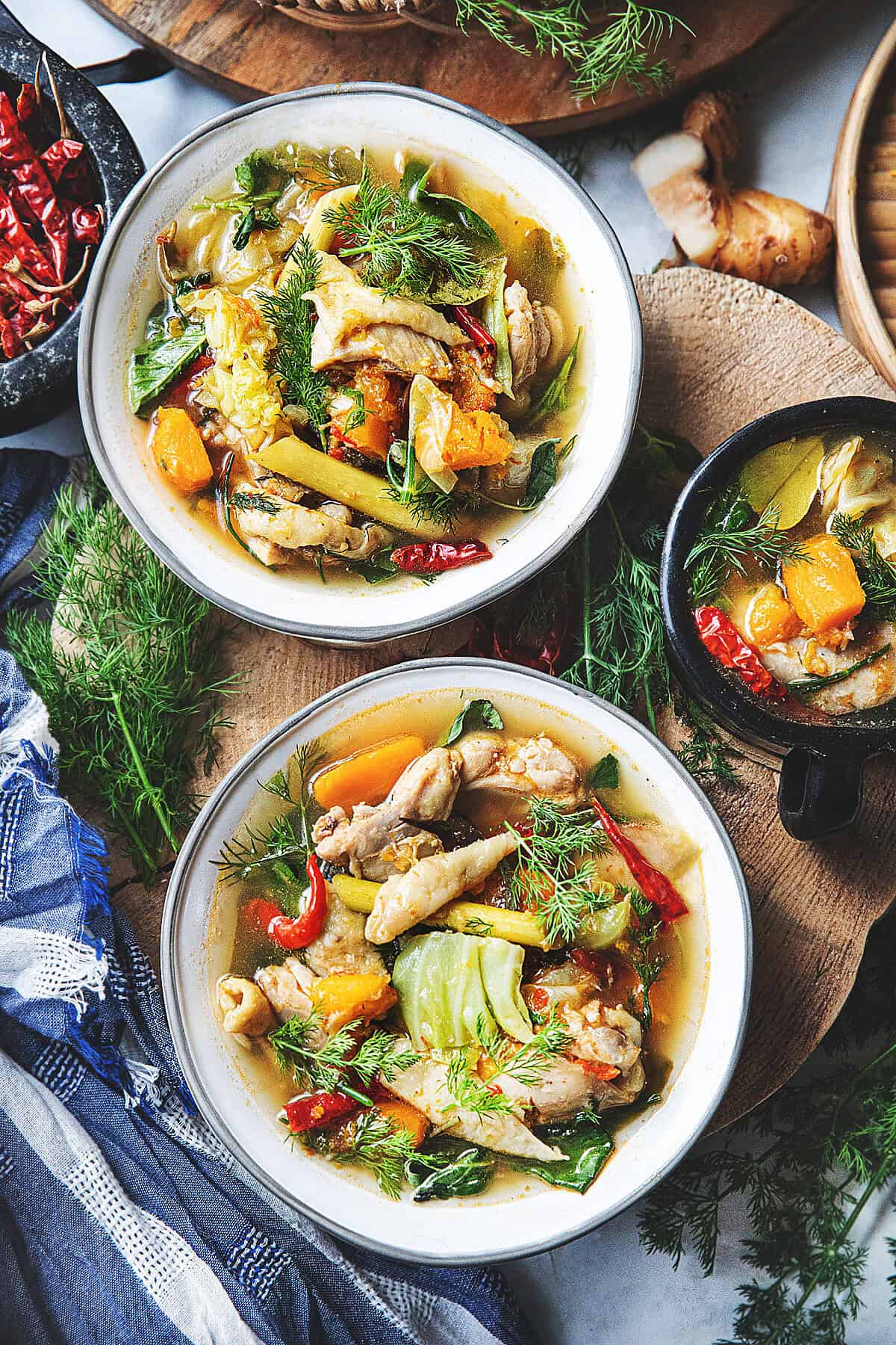 Gaeng Om Gai Isaan chicken soup with herbs, vegetables, and clear broth served with dill and Thai basil.