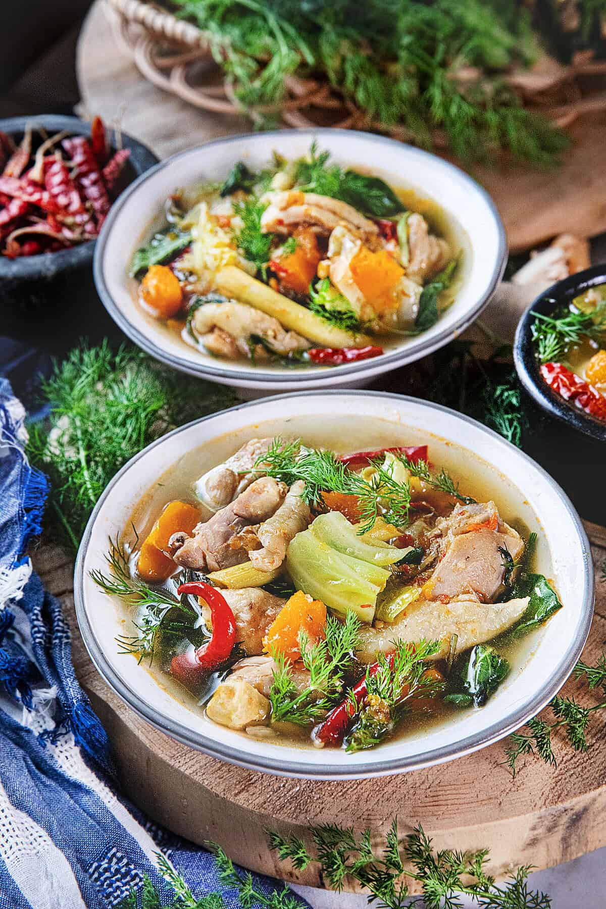 Gaeng Om Gai Isaan chicken soup with herbs, vegetables, and clear broth served with dill and Thai basil.