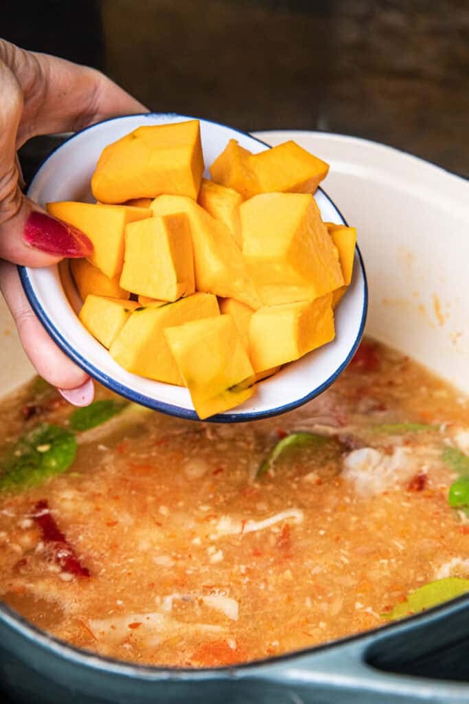 Adding kabocha squash to Gaeng Om Gai during cooking for natural sweetness and body