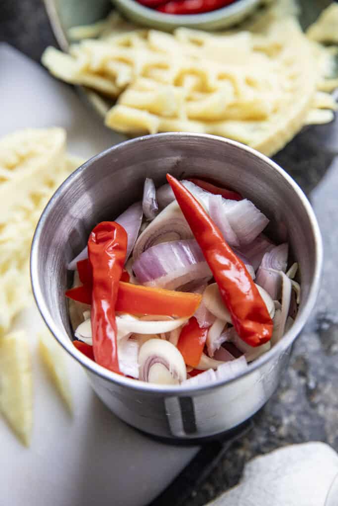 Chilies, lemongrass and shallot for making Isaan bamboo shoots soup paste in a spice grinder.