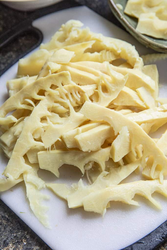 Sliced bamboo shoot tips for bamboo soup on cutting board.