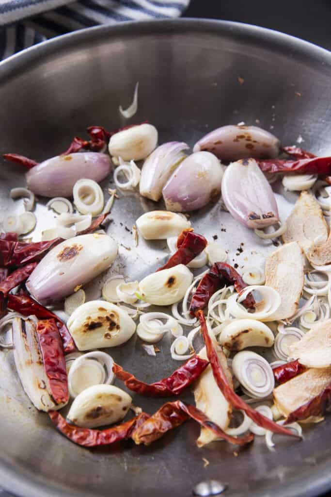 Toasting dried chilies and sliced lemongrass for Isaan-style Jeow Bong.