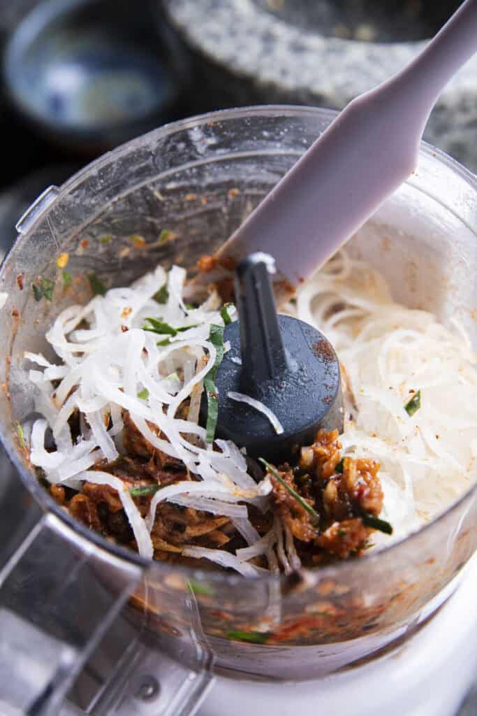 Adding cooked pork skin to Jeow Bong chili paste for texture.