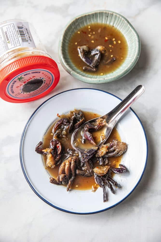Fermented crab for som tum on a plate with a spoon.