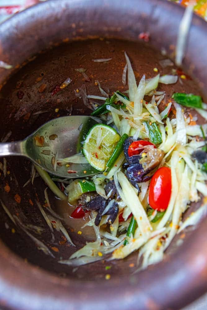 Isaan som tum pu pla ra mixed in clay mortar.