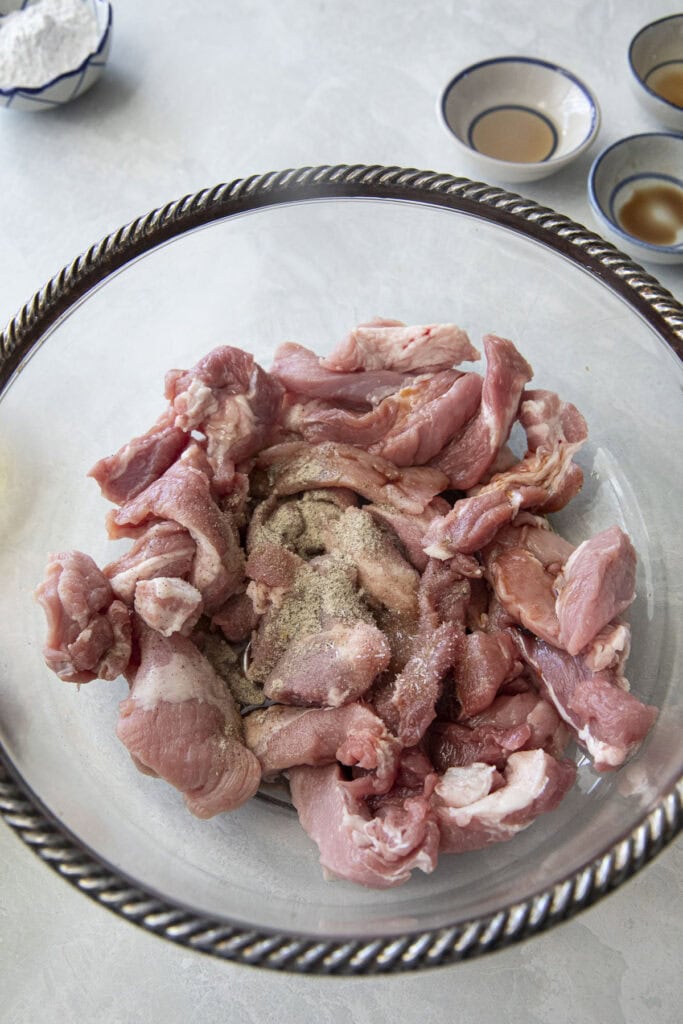 Thinly sliced pork prepared for Moo Tod Thai fried pork.