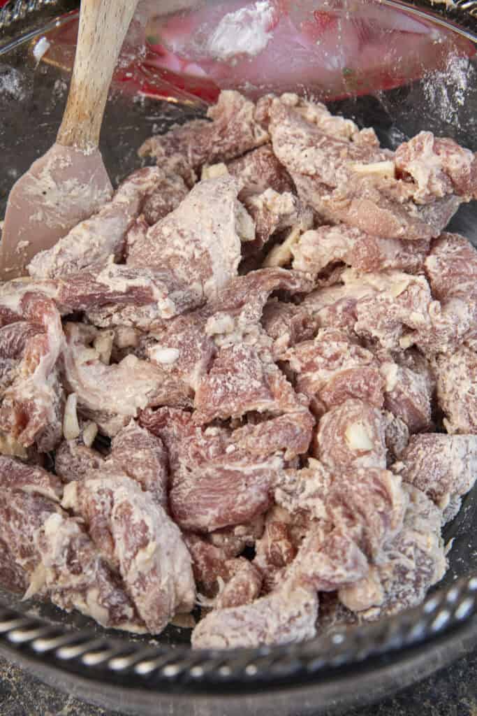 Coating marinated pork for moo Tod , lightly with cornstarch before frying.