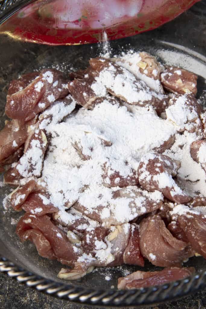 Coating marinated pork lightly with cornstarch before frying.