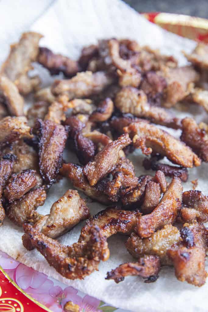 Crispy Moo Tod Thai fried pork draining on paper towel.