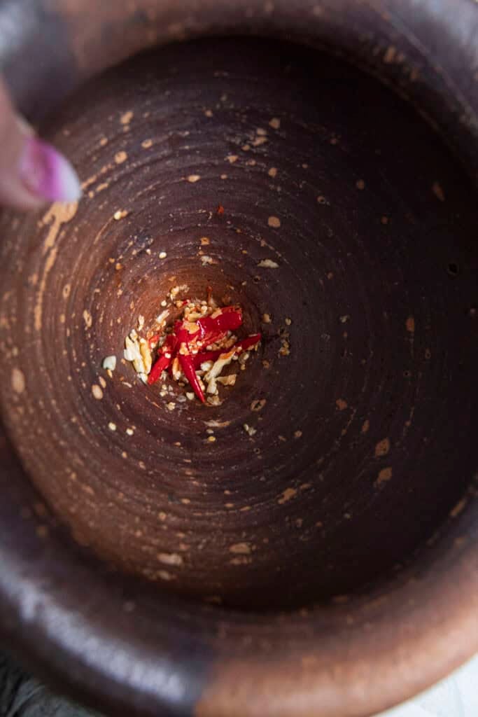 pounding garlic and chilies in thai mortar
.