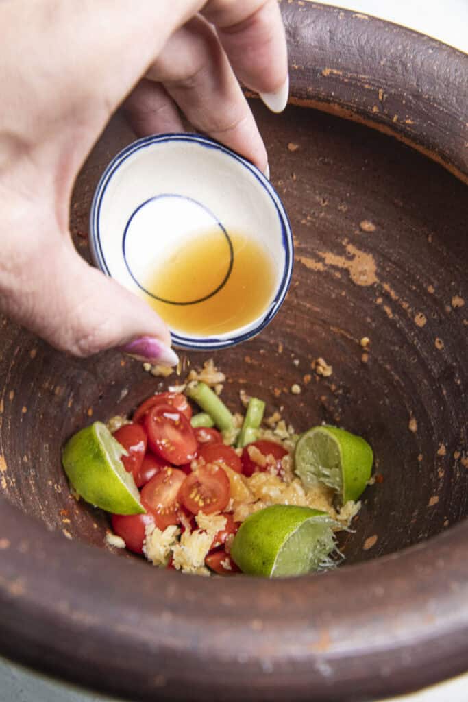 Fish sauce added to som tum dressing.