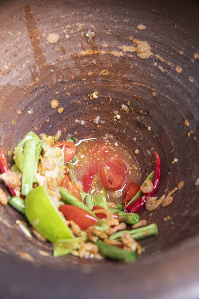 Thai papaya salad dressing in clay mortar.