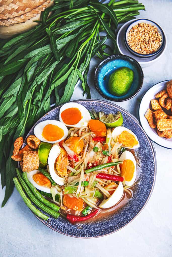 Thai papaya salad salted egg plated with thai vegetables.