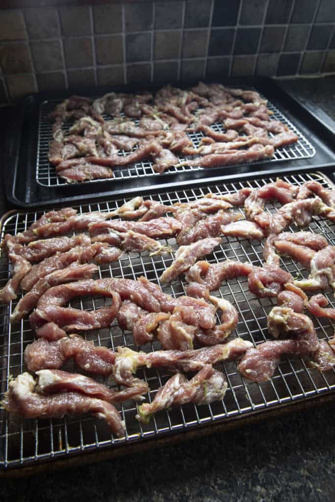 thai sun dried pork strips on a baking rack.