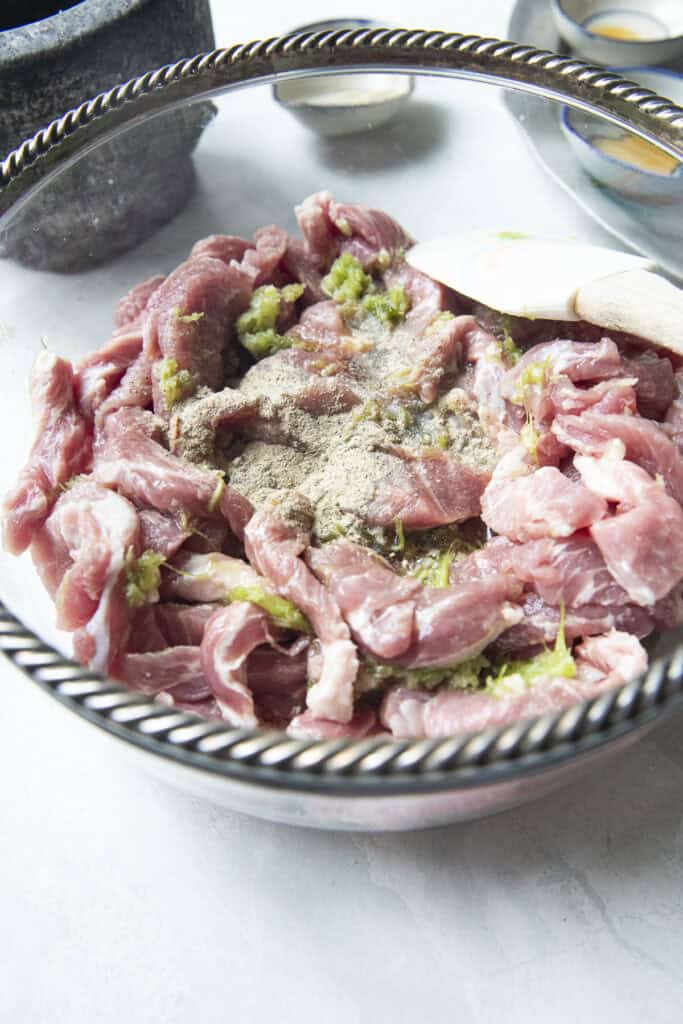 Seasoning pork strips for moo dad deaw recipe.