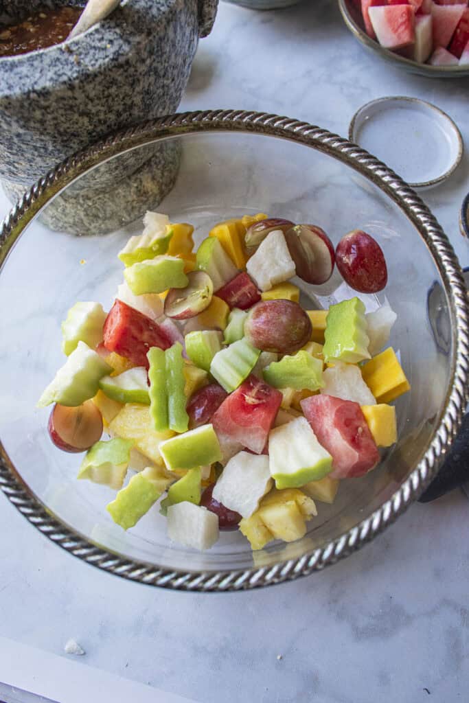 A mixed of chopped Thai fruits salad in a glass bowl.