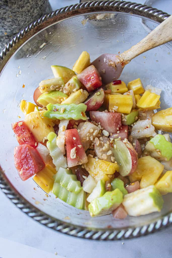 Colorful thai fruit salad with peanuts and chilies.