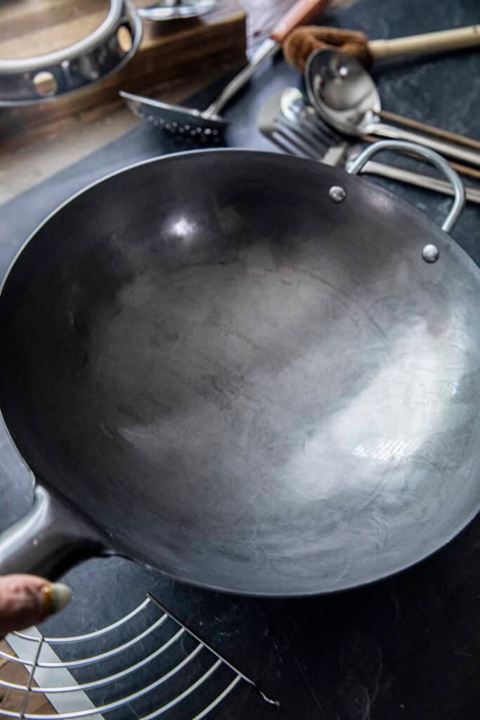Close-up front view of a non-seasoned carbon steel wok before seasoning.