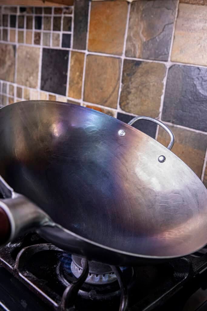 Carbon steel wok turning blue from heat during the seasoning process.