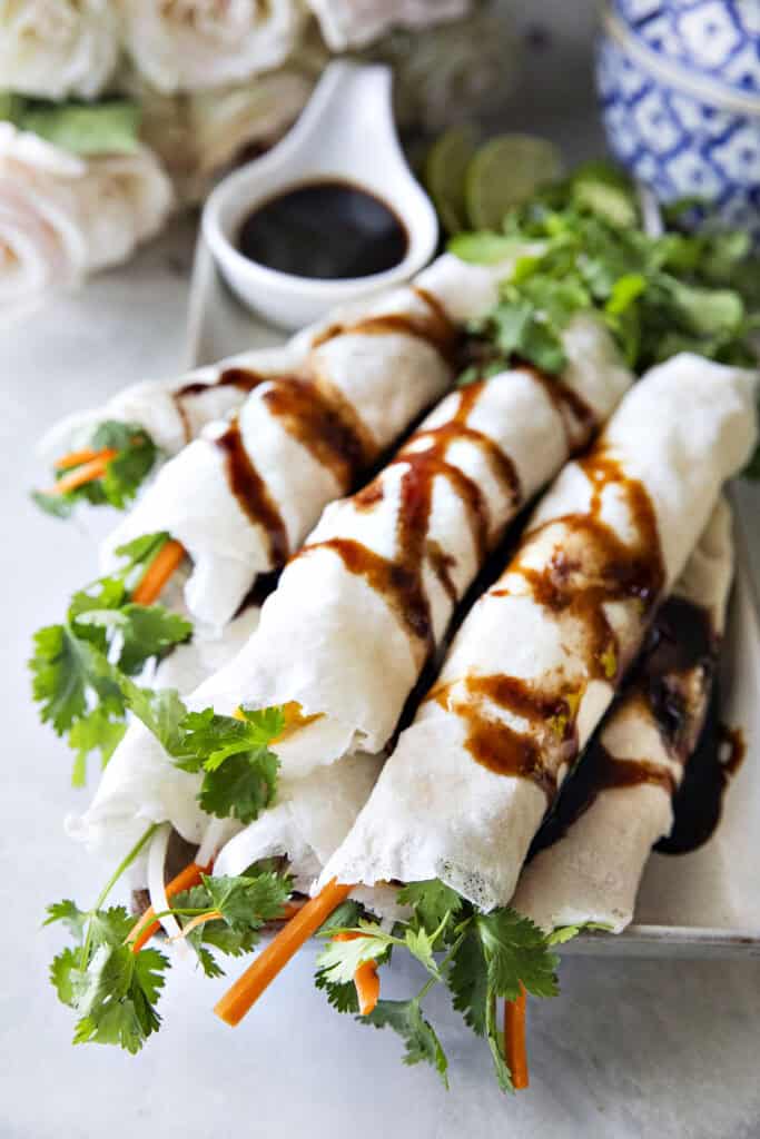 Thai fresh spring rolls topped with sweet savory sauce, fried shallots, and sliced chilies.