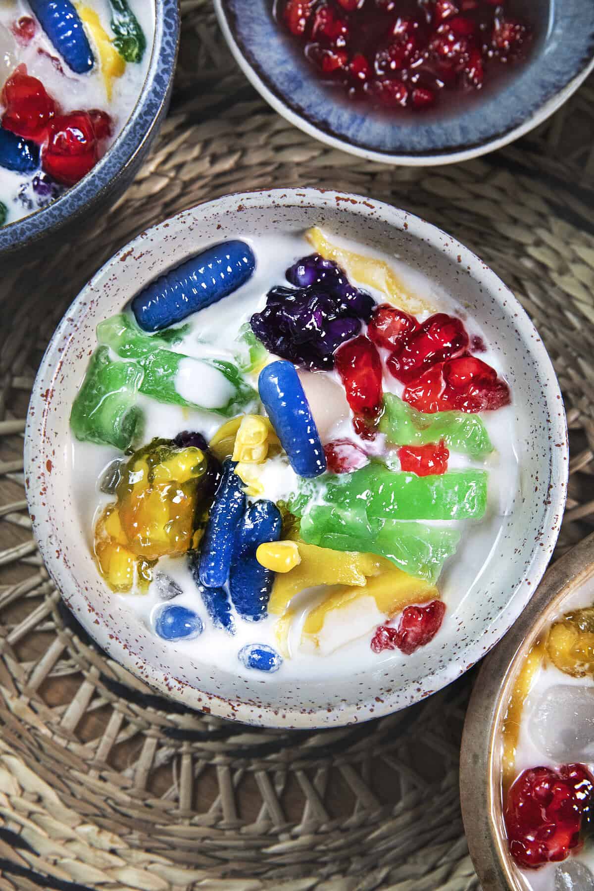 Overhead view of colorful Ruam Mit Thai mixed dessert with tapioca noodles, fruit, coconut milk, and crushed ice.