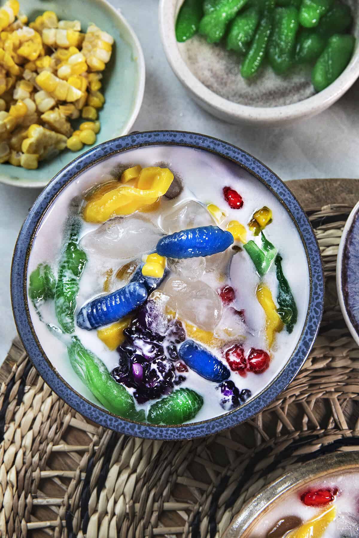 Close-up of Ruam Mit with colorful chewy tapioca pieces, jackfruit, sweet corn, coconut milk, and crushed ice.