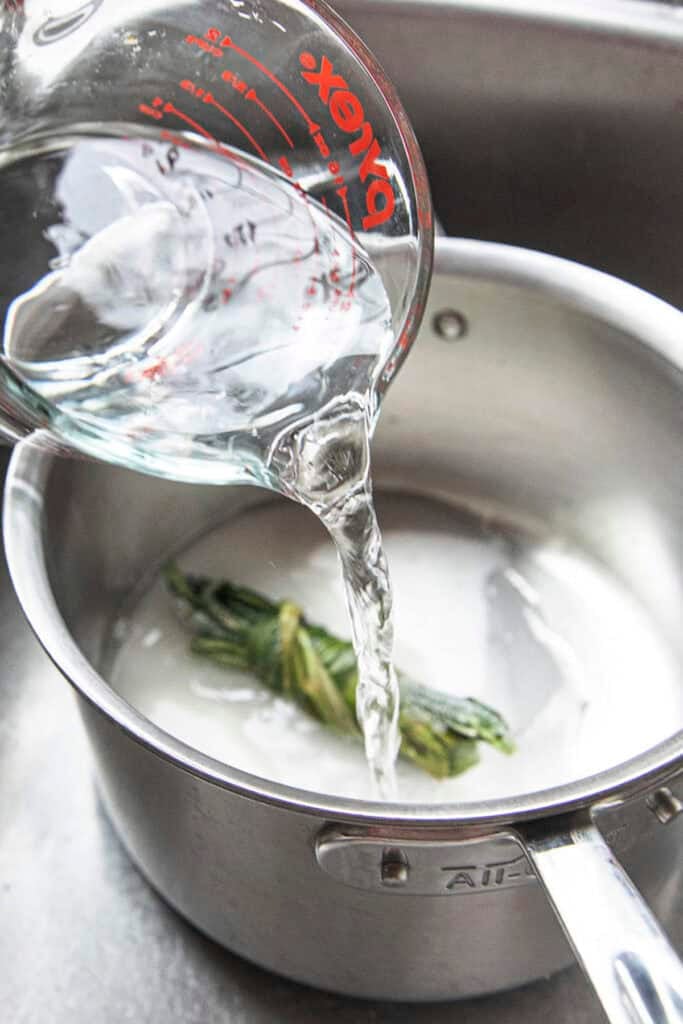 Water pouring into a pot for making Jasmine essence for Ruam Mit syrup.