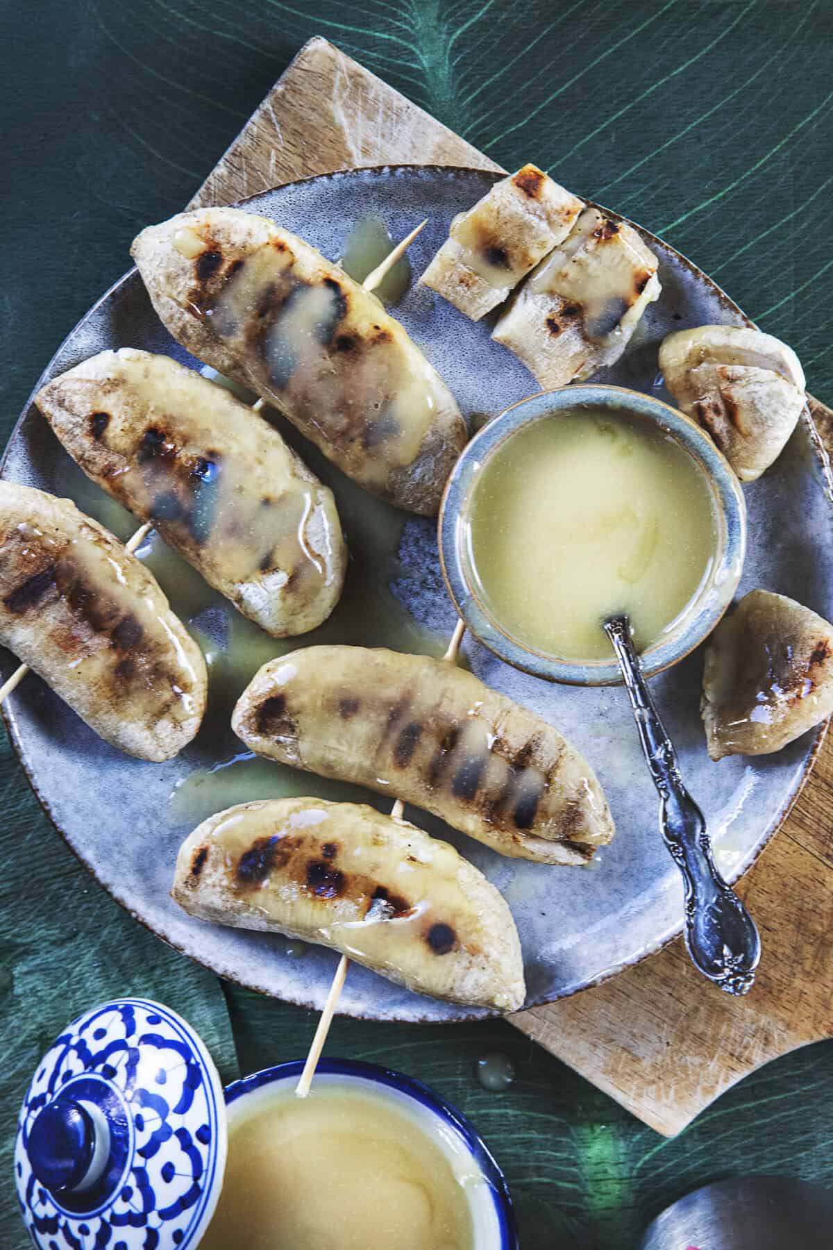 Grilled Nam Wa bananas with caramelized grill marks and caramelized coconut sauce.