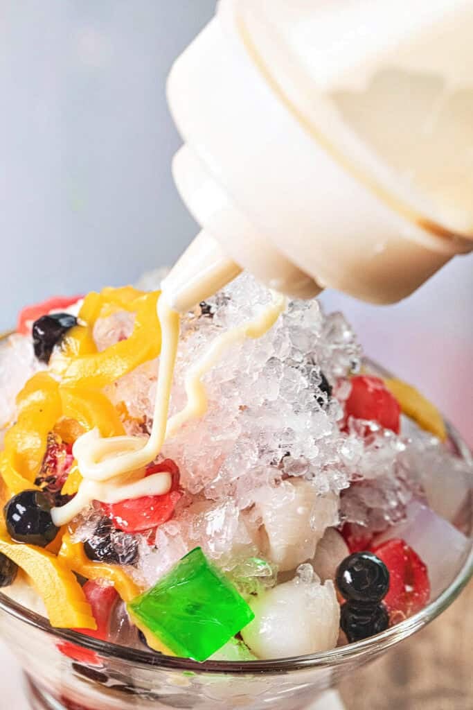 Sweetened condensed milk drizzled over Nam Khaeng Sai Thai shaved ice.