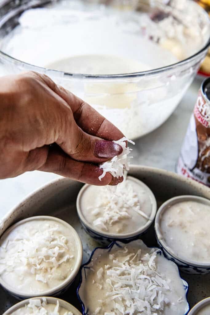 Adding Shredded coconut on top of Thai steamed banana dessert.