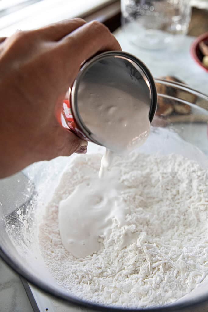 Coconut milk being added to Khanom Kluay batter.