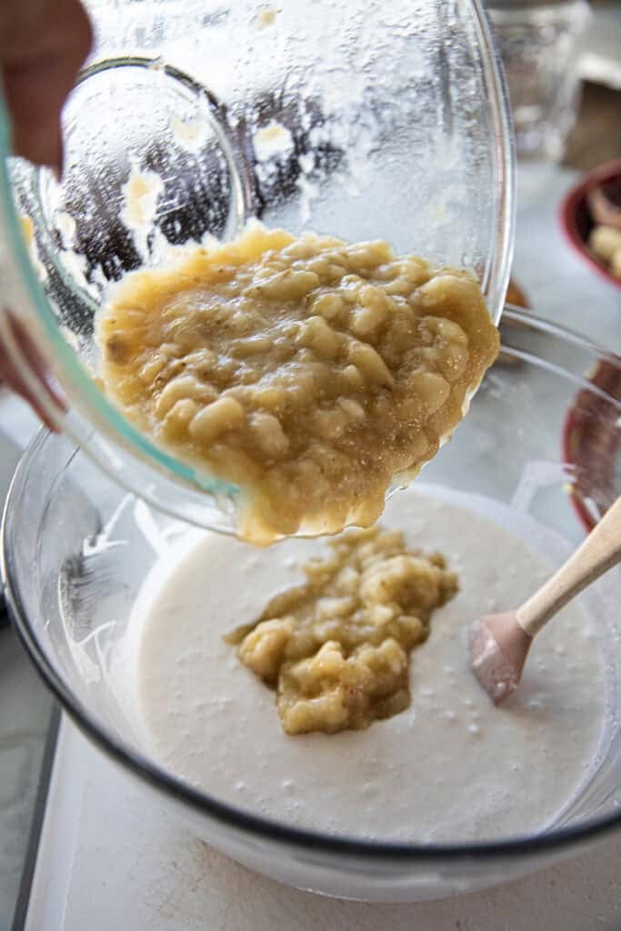 Mashed Nam Wa bananas being mixed into coconut batter.